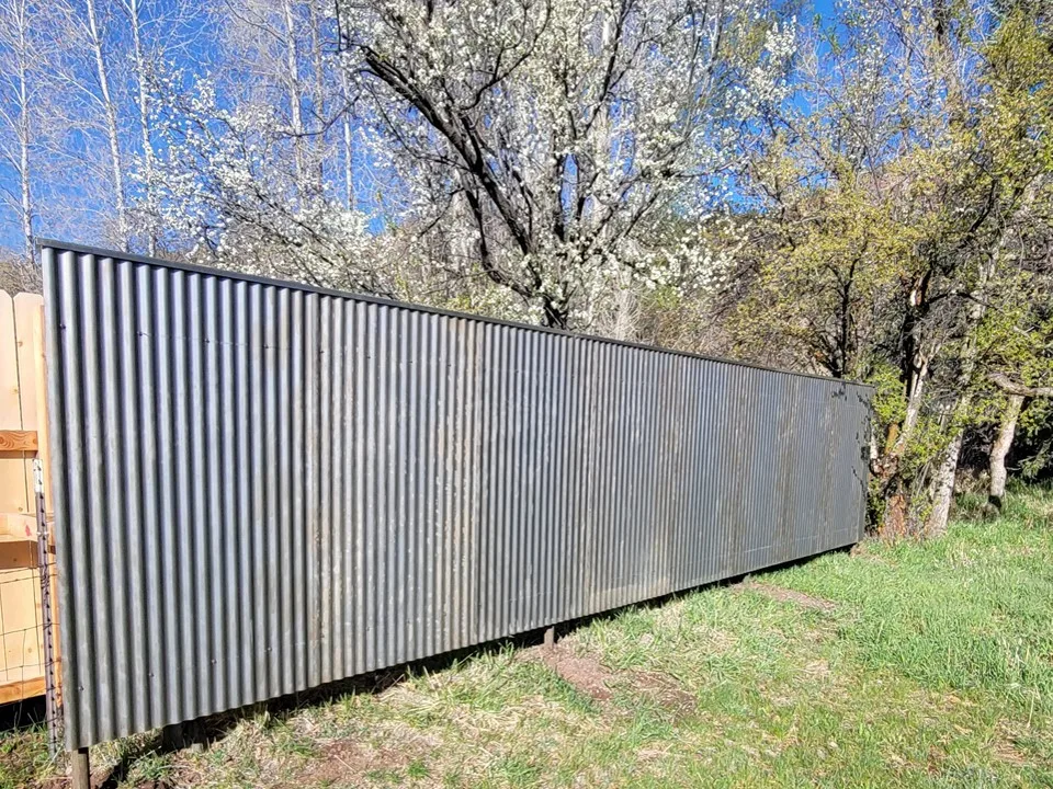 Corrugated metal fence panel with steel posts